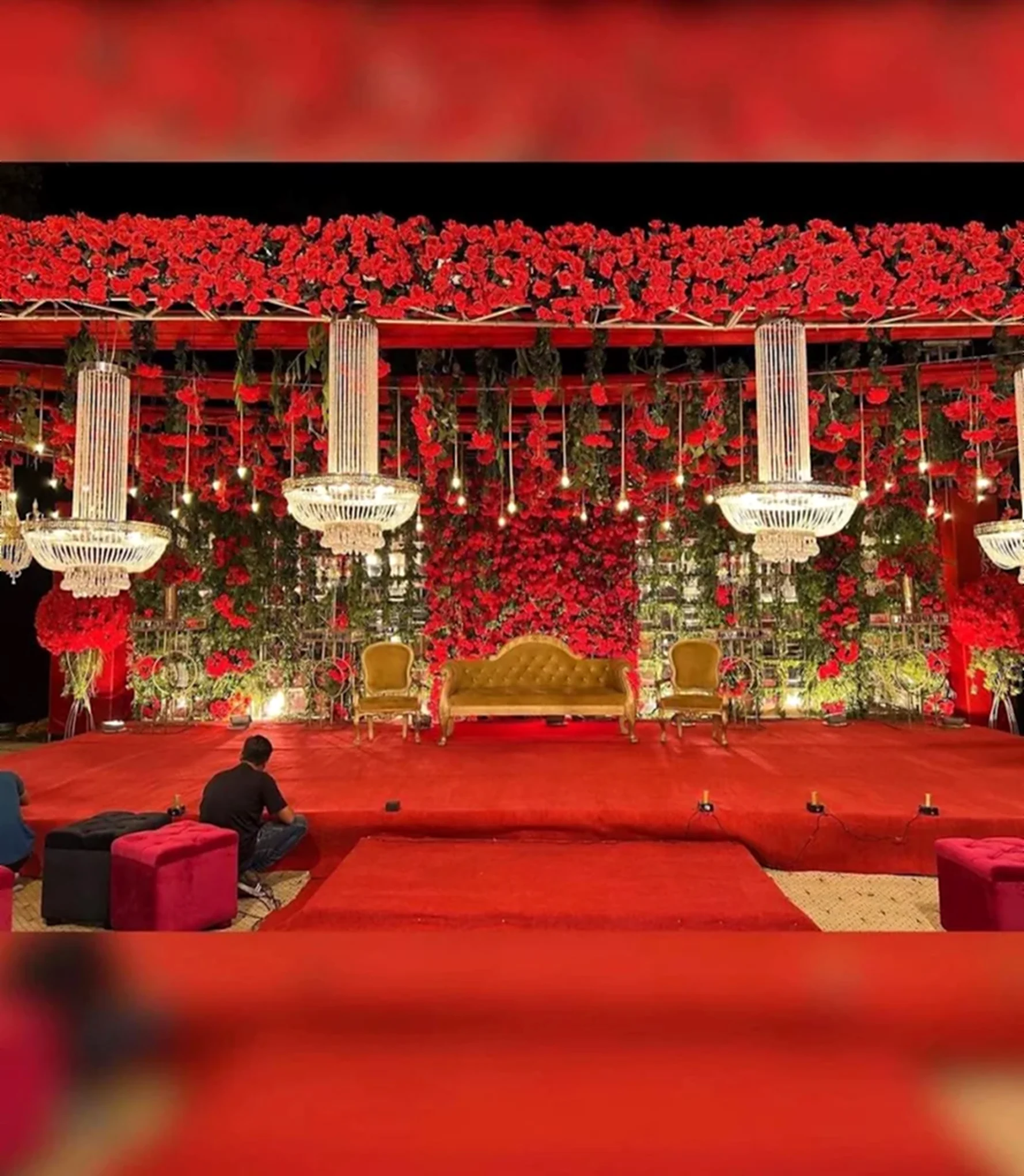 Red rose flower wall stage with chandeliers and gilded seating